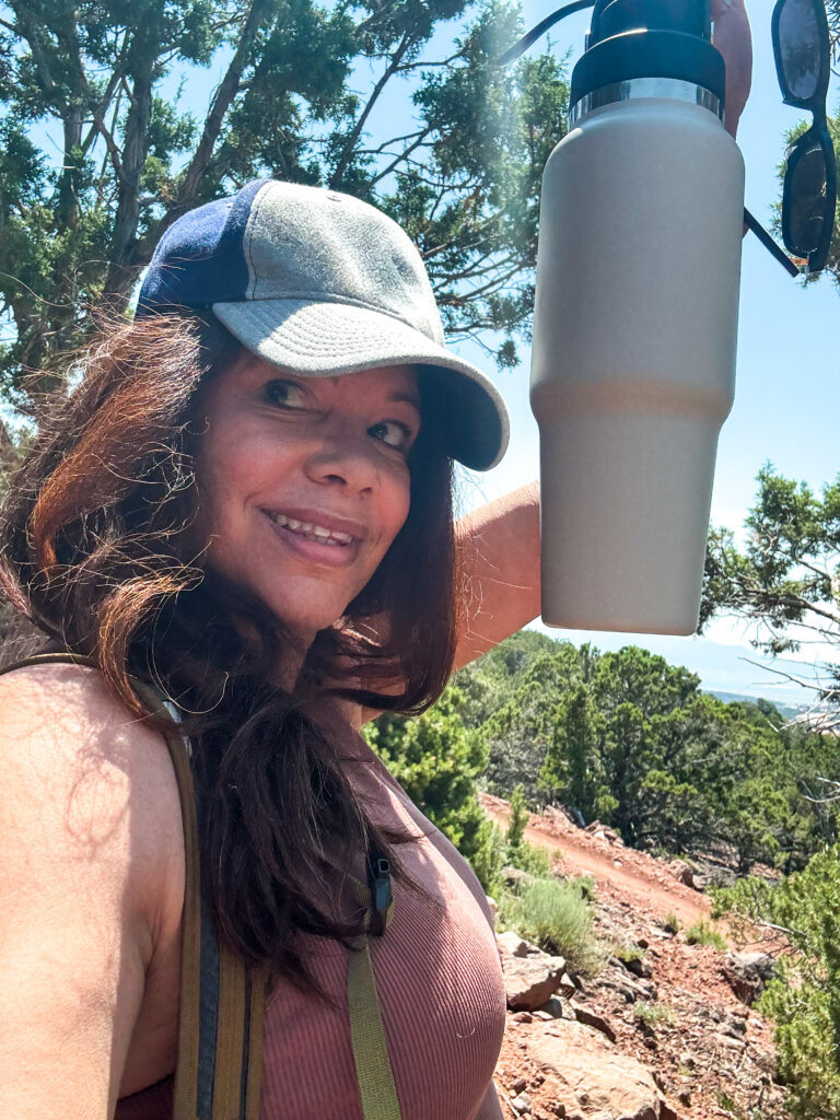 woman holding insulated tumbler during outdoor adventure with best outdoor gear for women