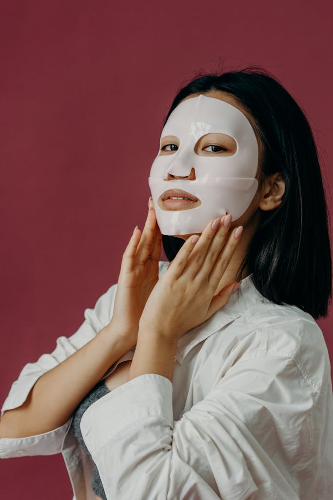 Asian woman applying BIODANCE hydrogel face mask during self-care skincare routine – Sugar & Snip beauty blog