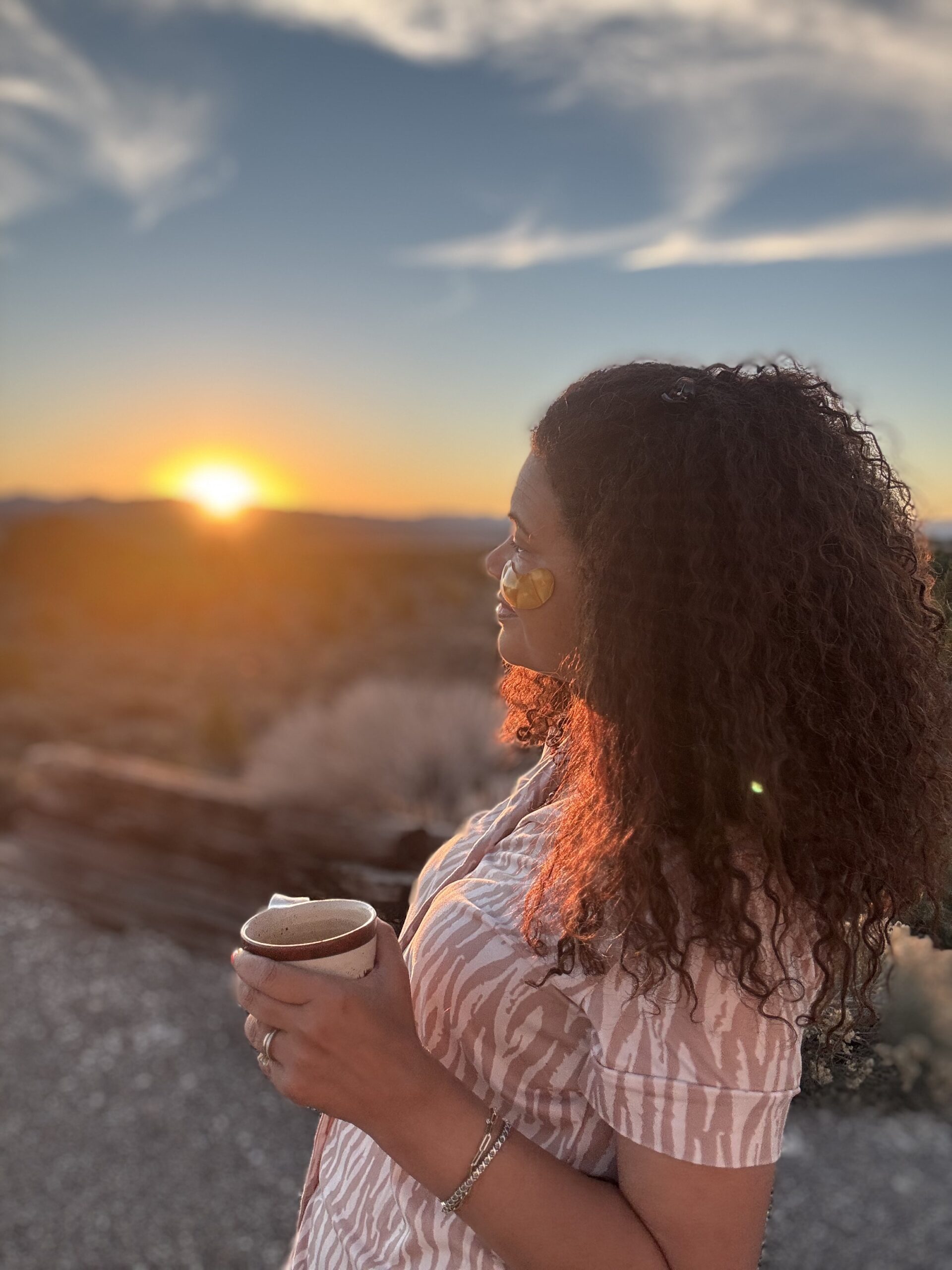 black woman looking away into sunrise wearing eye patches