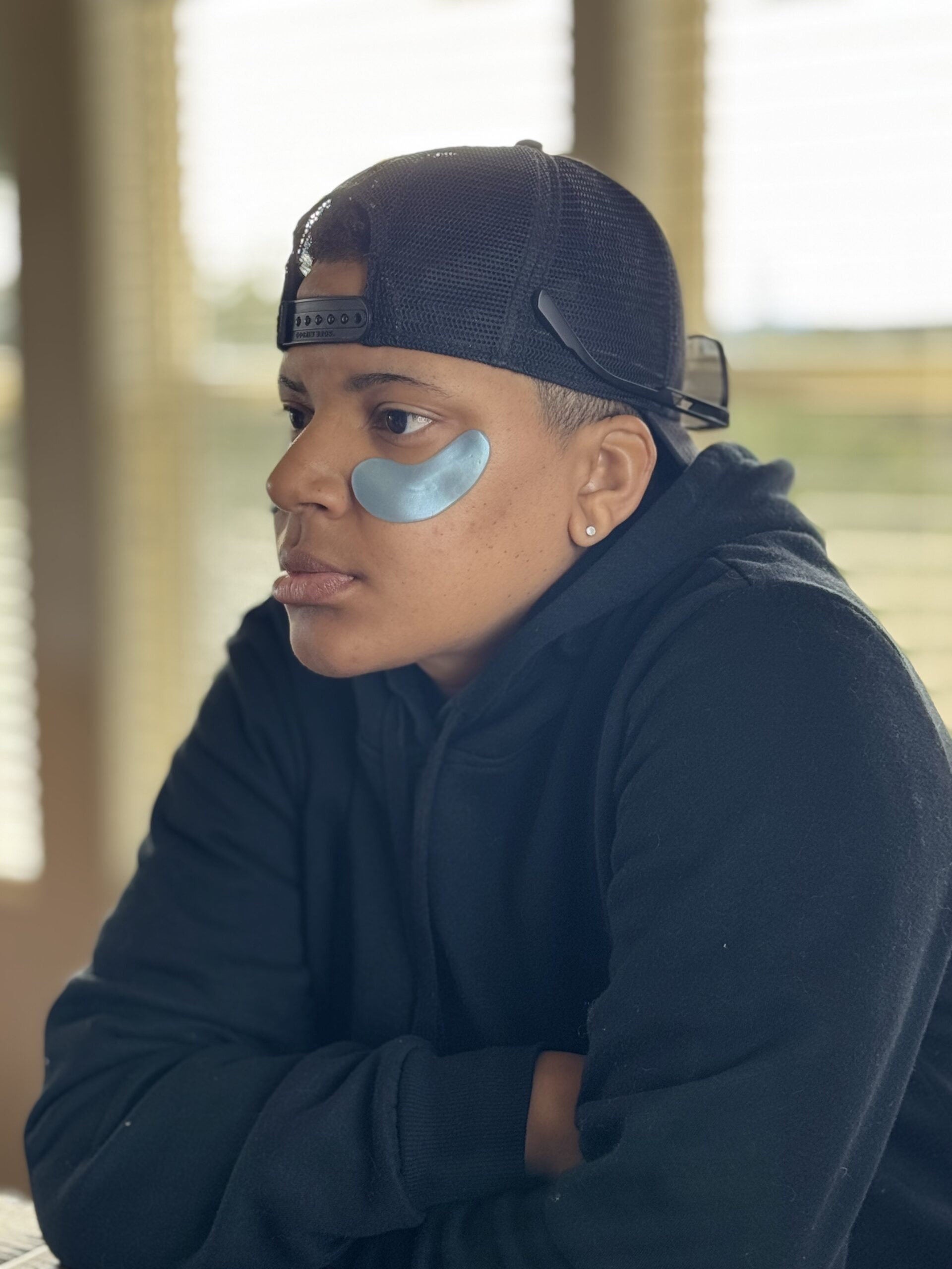 side profile black woman wearing blue eye patches