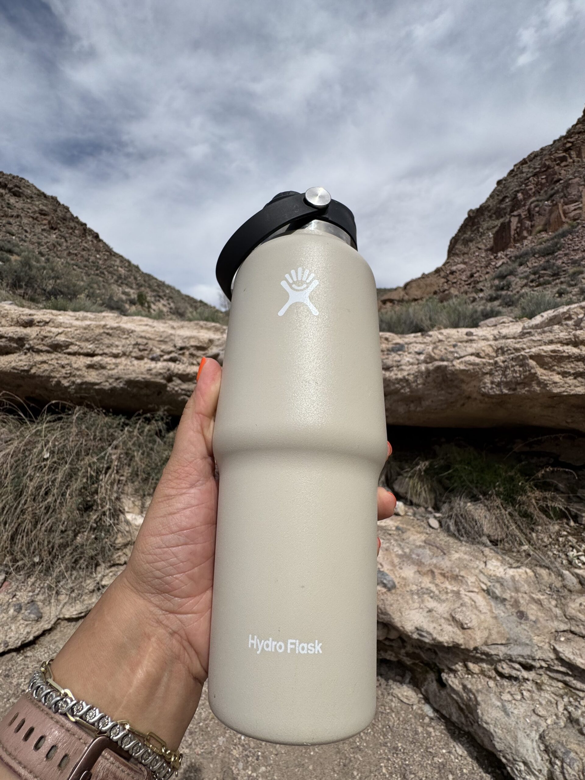 water bottle held up against desert rock