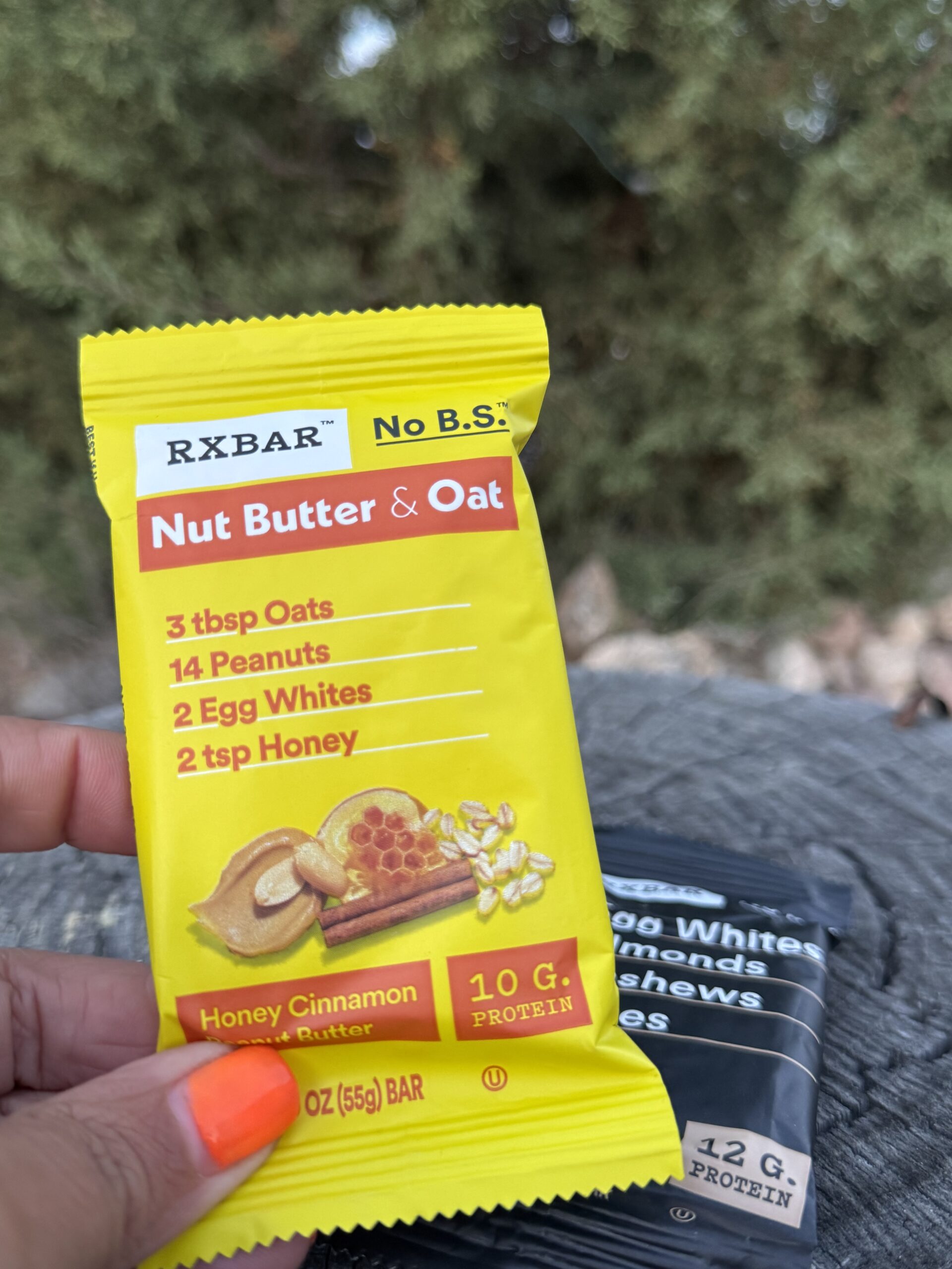 Close up of hand holding RXbar energy and protien bar with another bar in the background