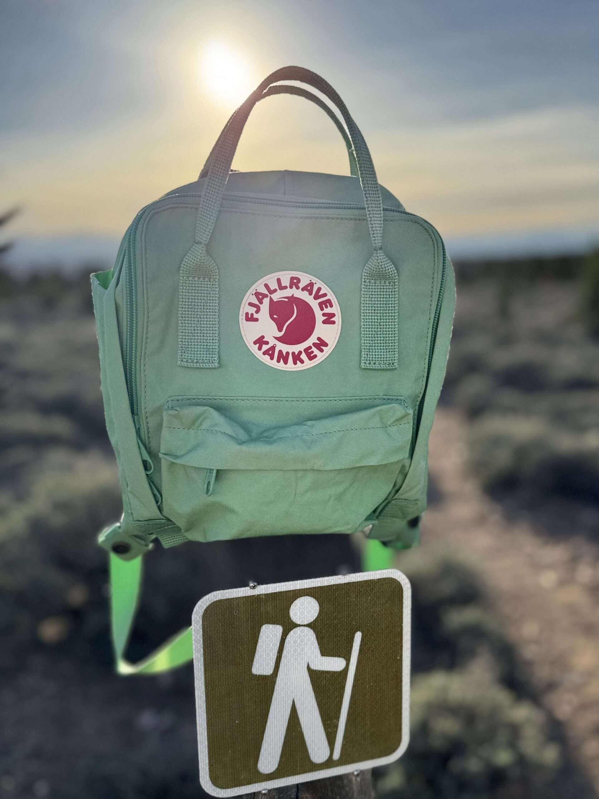 green backpack on top of trailhead sign in Nevada desert landscape