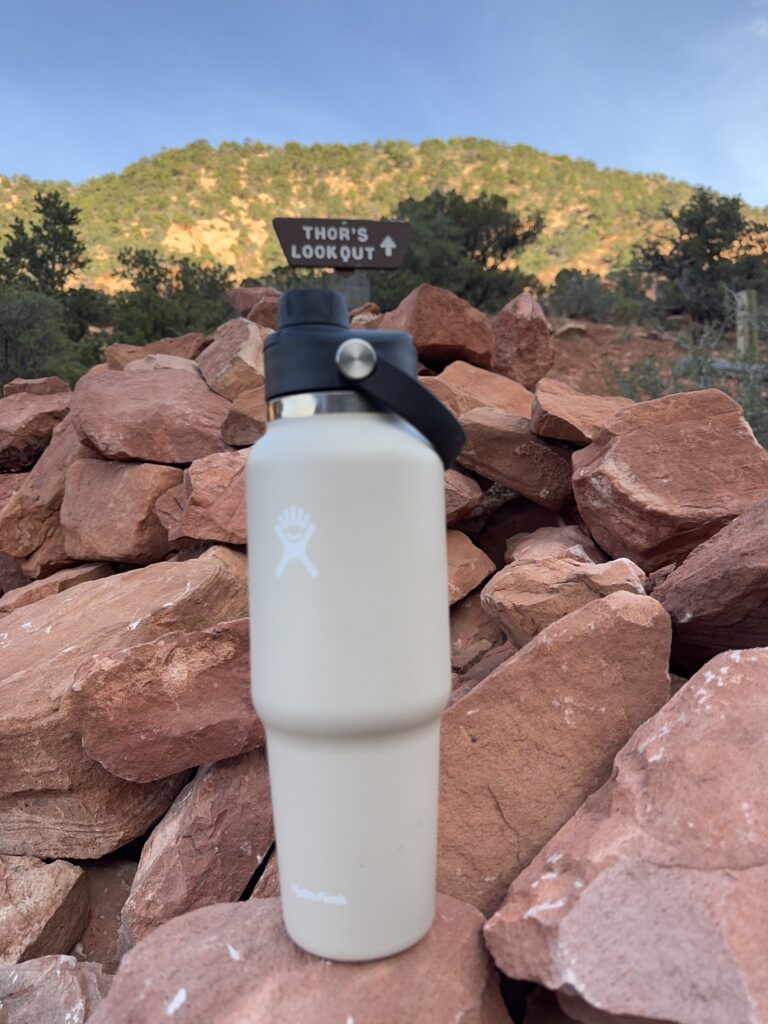 hydro flask water bottle rested on rock on hiking trail in utah