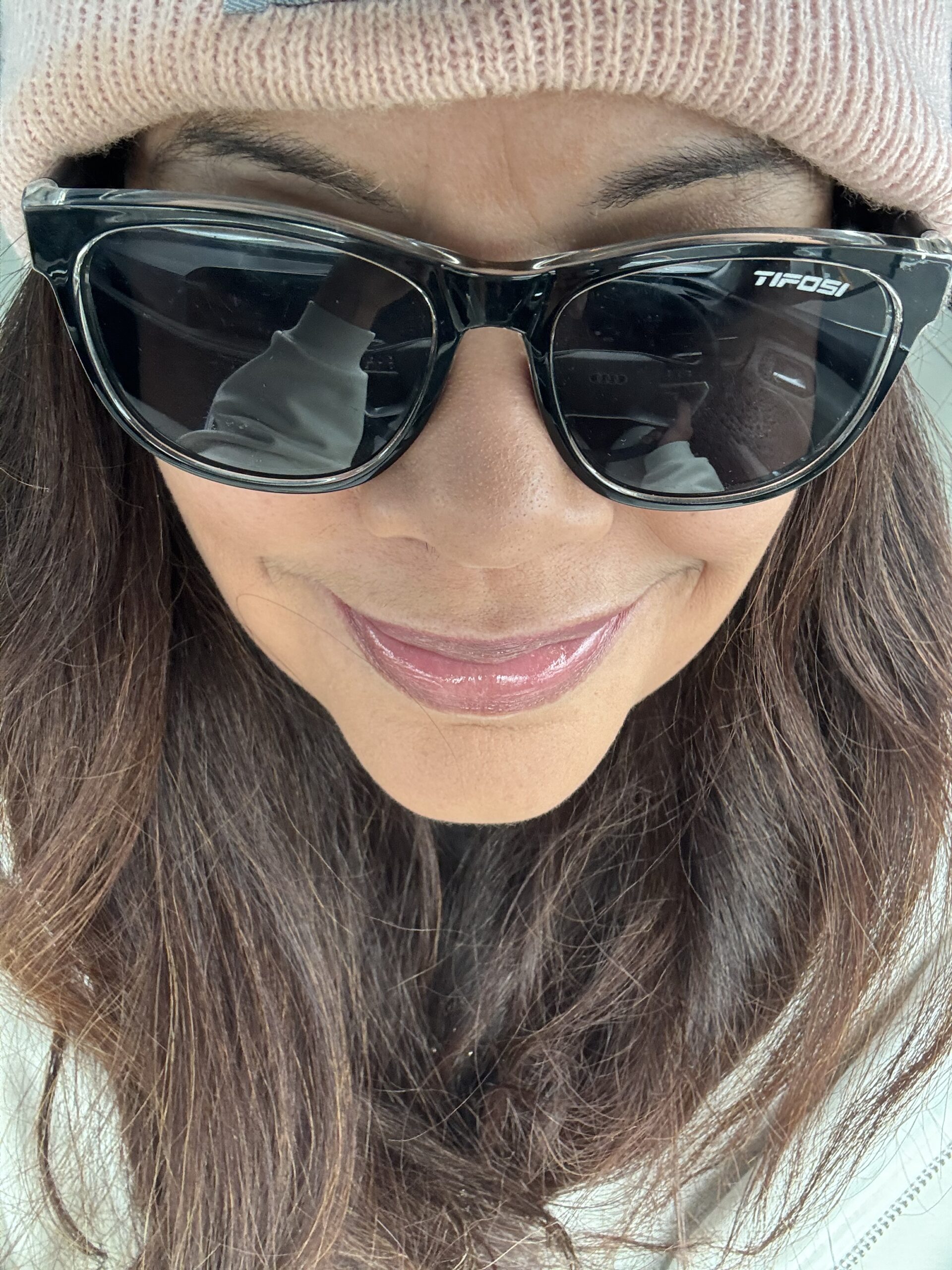 close up of black woman wearing sunglasses and a beanie