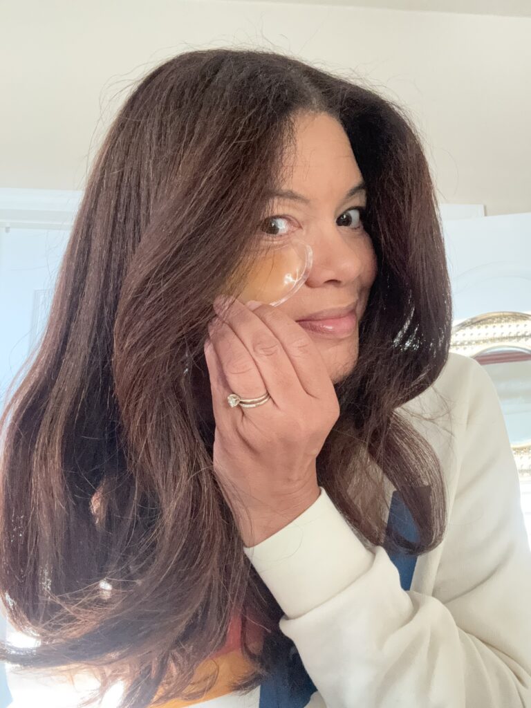 black woman applying eye patch in morning routine