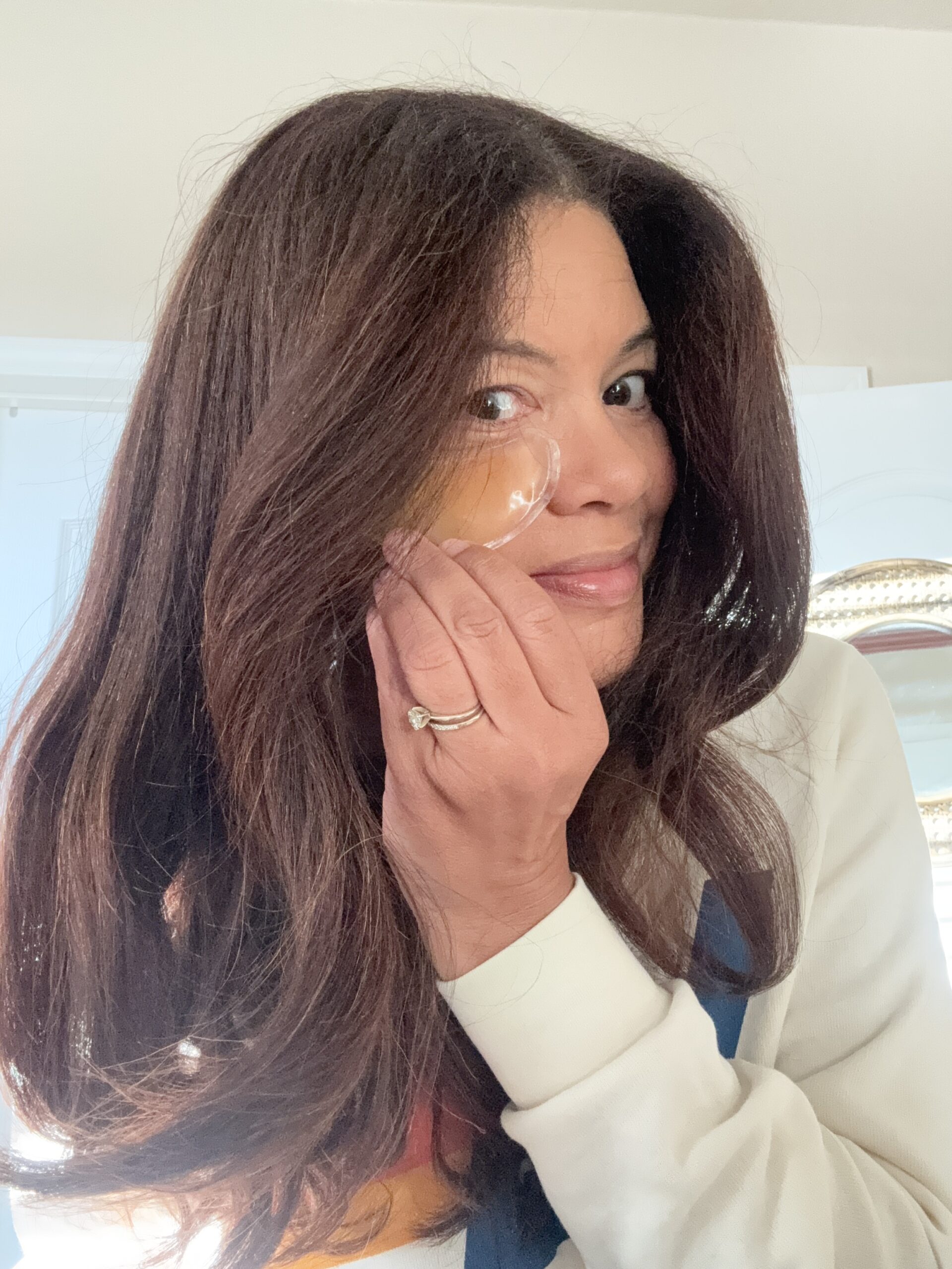 black woman applying eye patch in morning routine