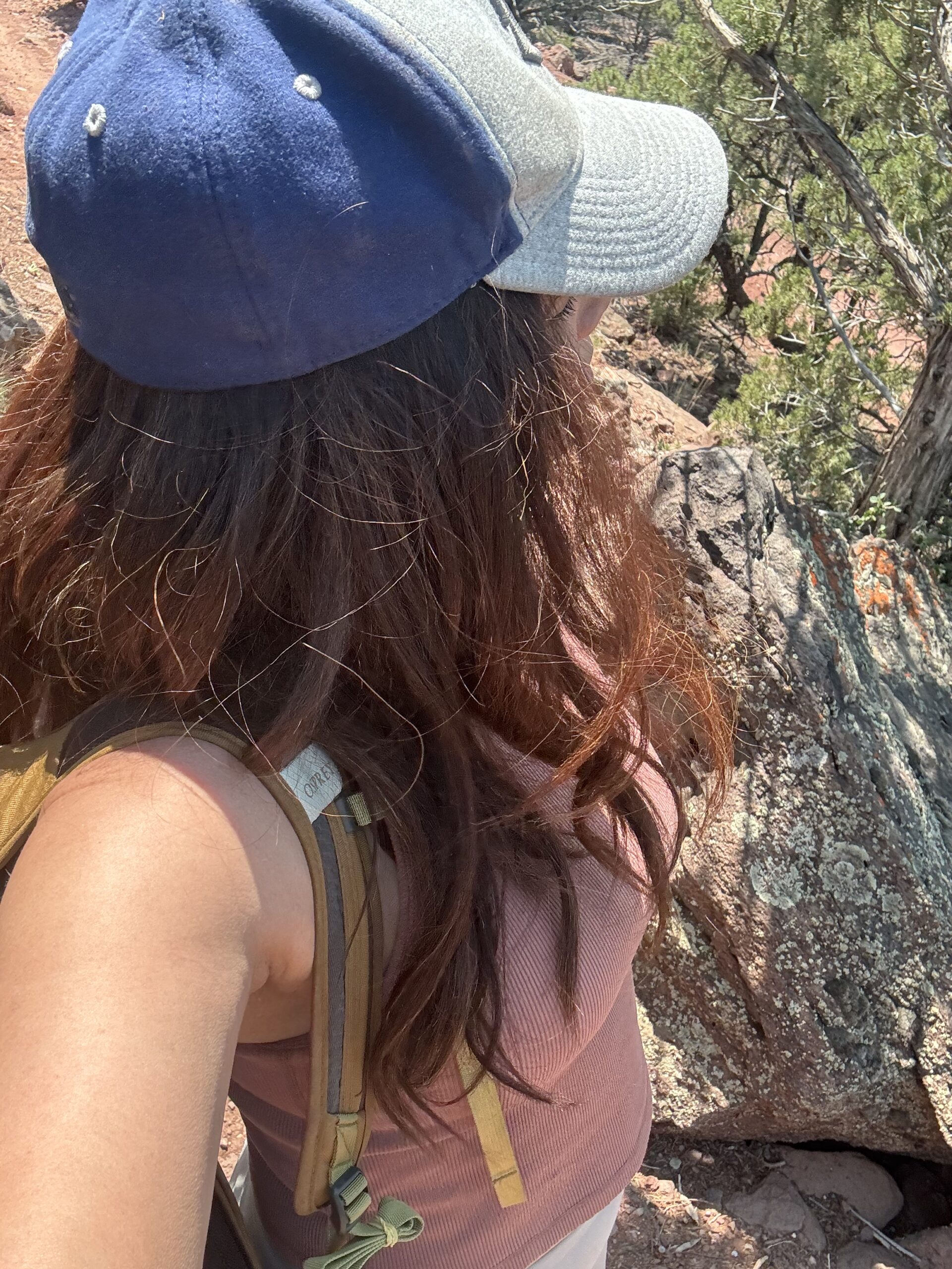 black woman wearing baseball hat and tank top on summer hike