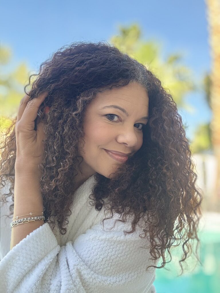 black woman with curly hair doing skin care routine