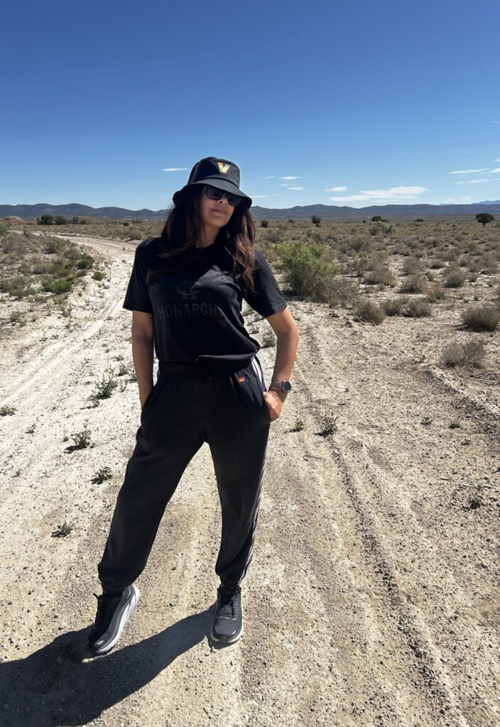 black woman in black joggers and tshirt and hat in desert road wearing casual outfit