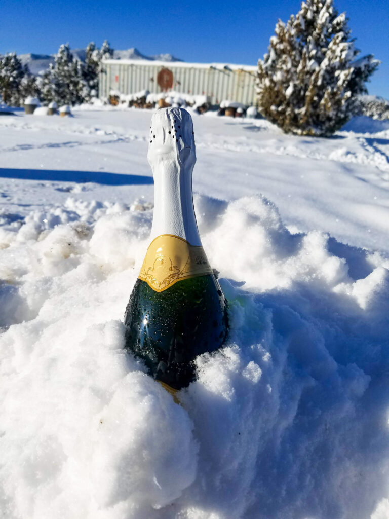 bottle of champagne in pile of snow