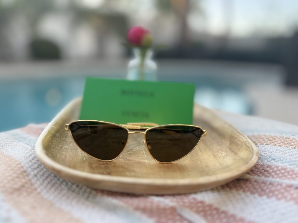 luxury bottega veneta sunglasses on tray with sunglasses case and flower bud in vase