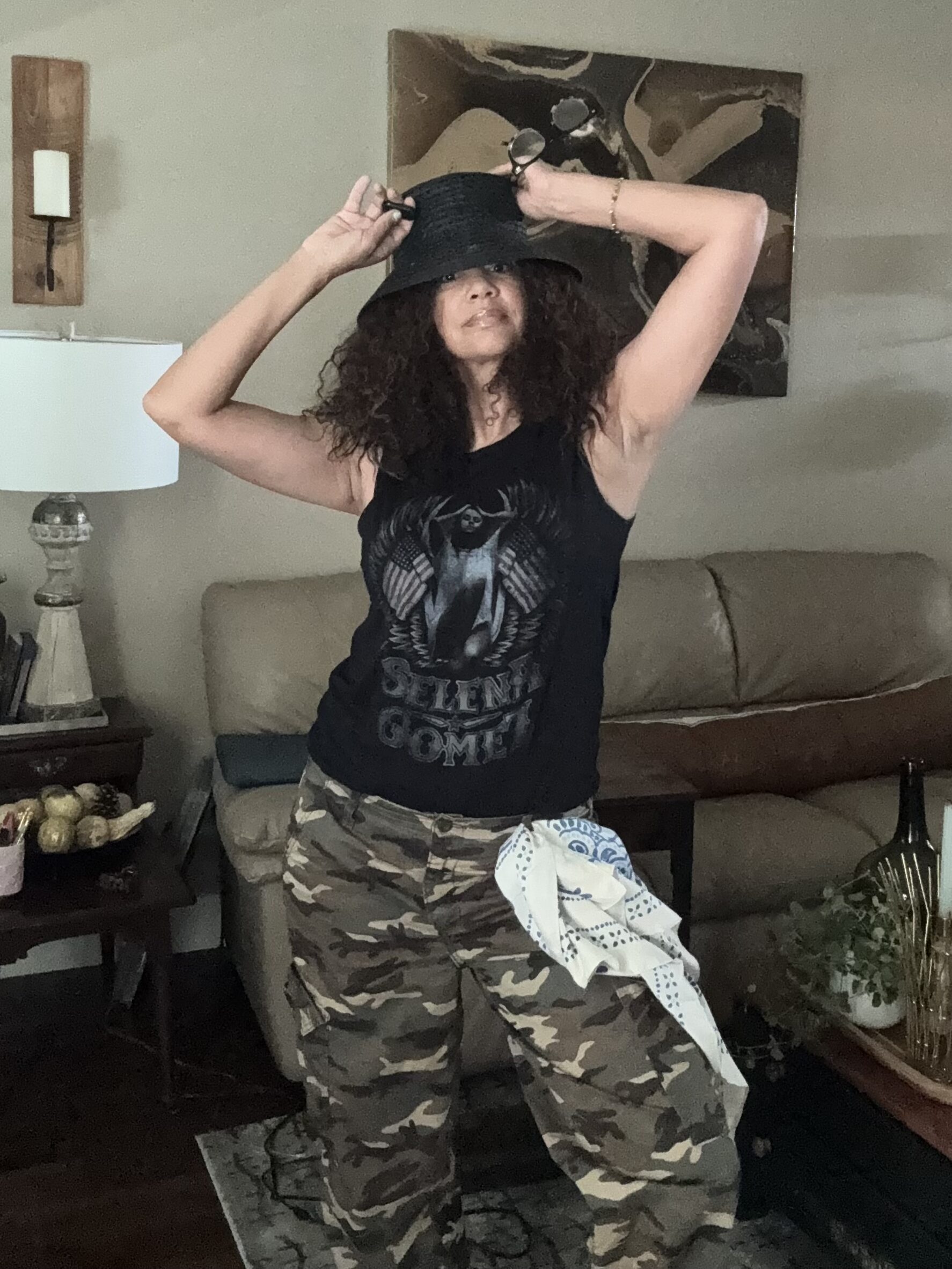 woman in bucket hat, tank top and camo pants