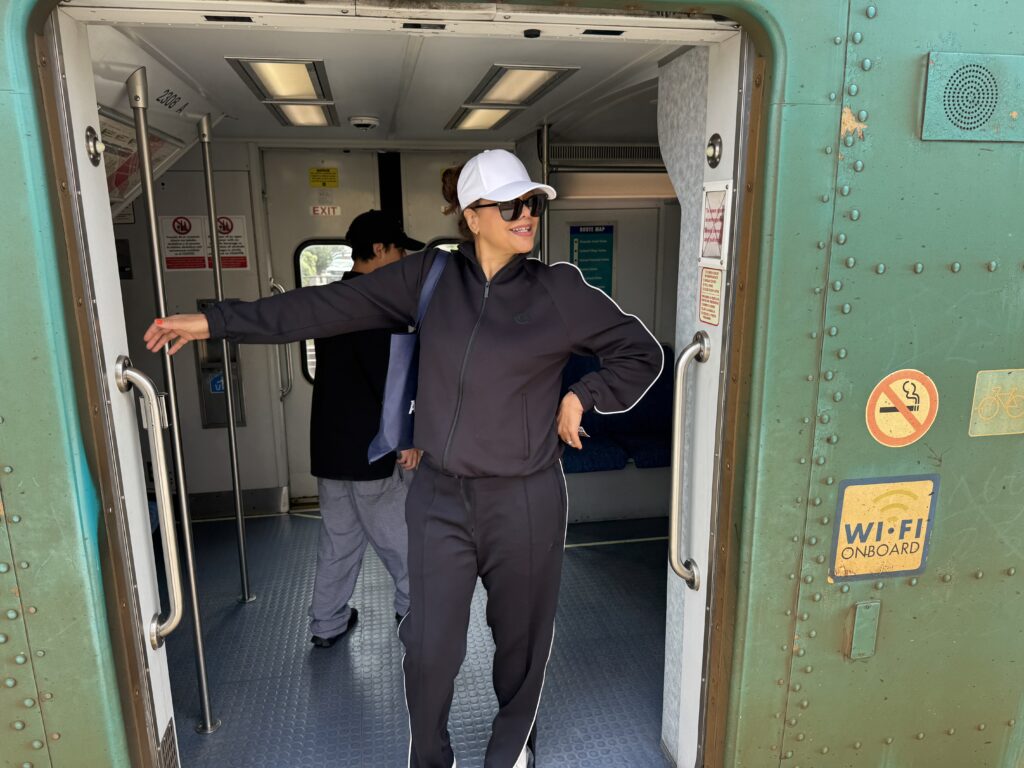 black woman in white visor sun hat in the door of a train