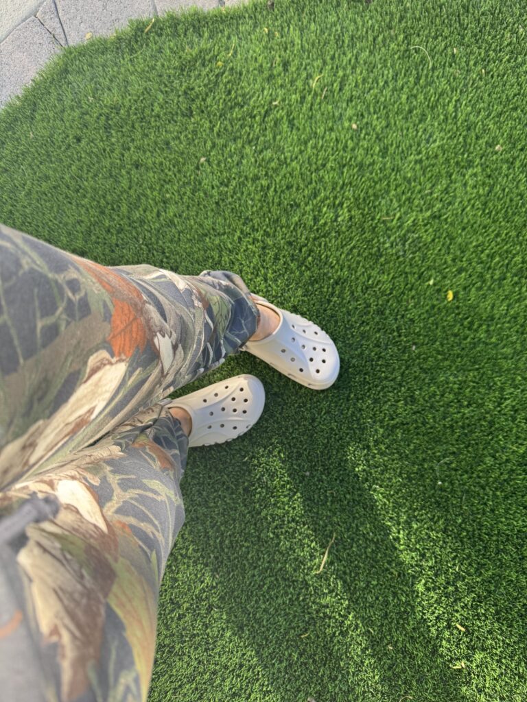 pink crocs on artificial turf